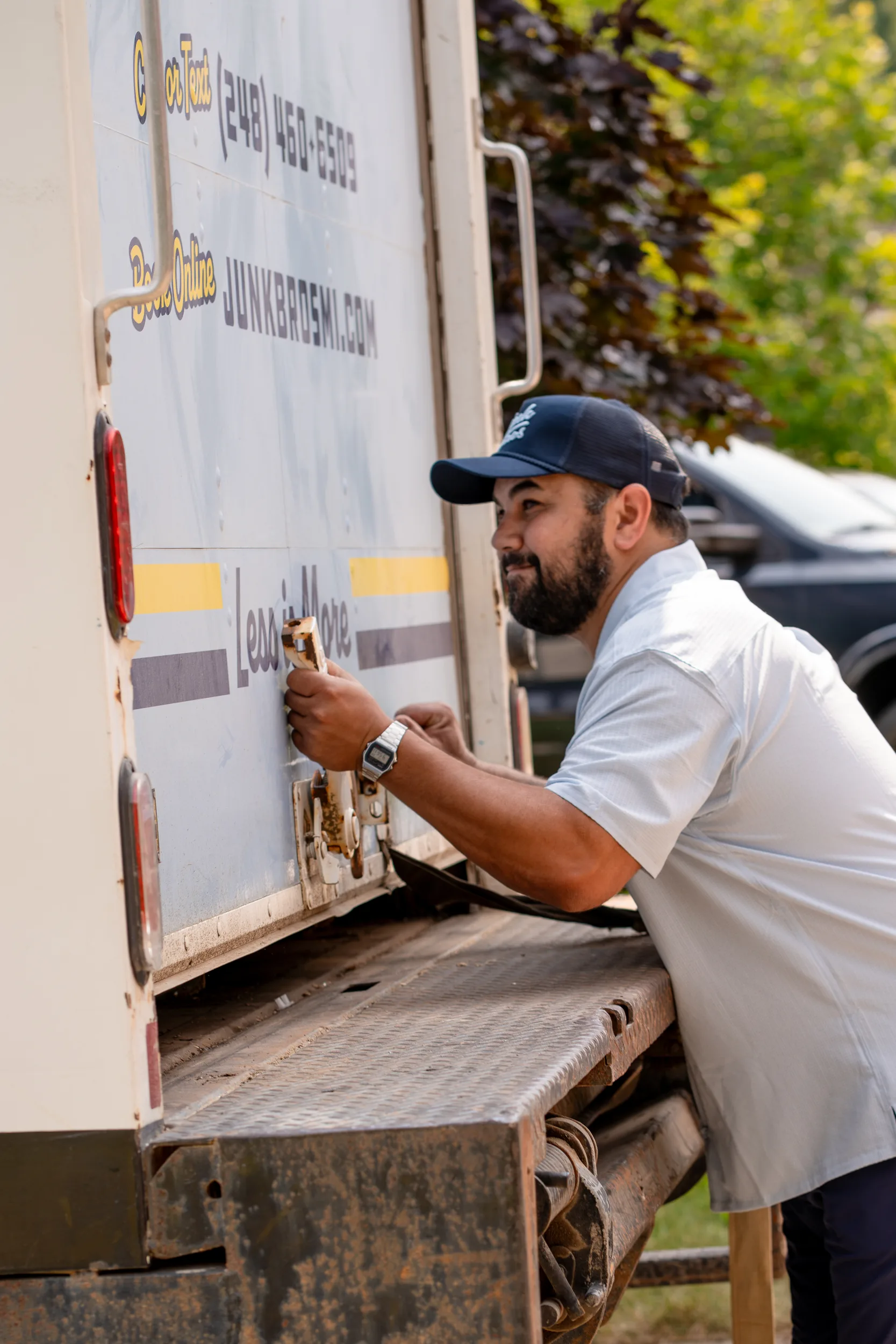 A Junk Bros crew member closing up the back of the loaded truck